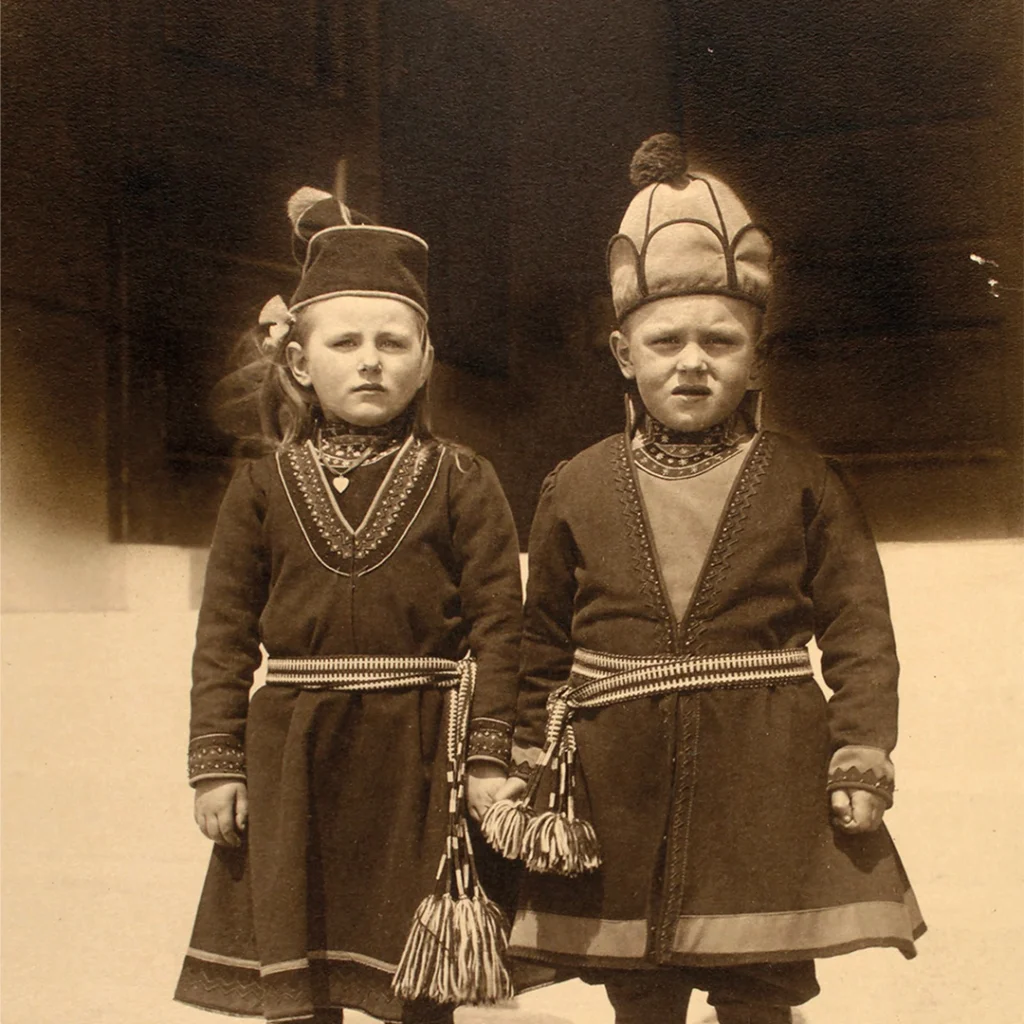 En flicka och en pojke klädda i samiska Arjeplogskoltar.